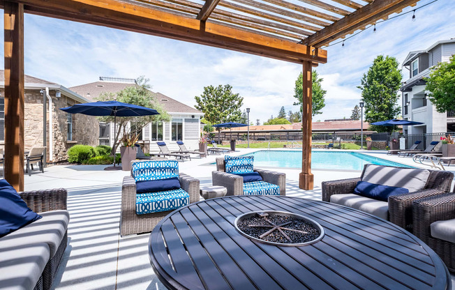 Outdoor seating with fire pit table in pool area