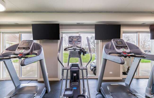 A gym with treadmills and elliptical machines.