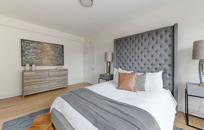 bedroom with bed, night stands, dresser and hardwood floors at the dahlia apartments in washington dc