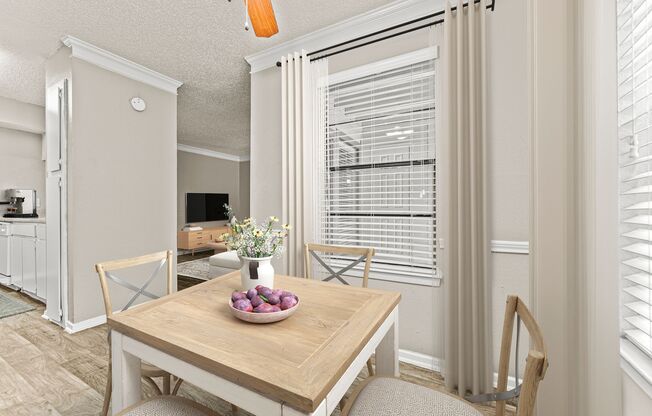 a dining room with a table and chairs and a large window