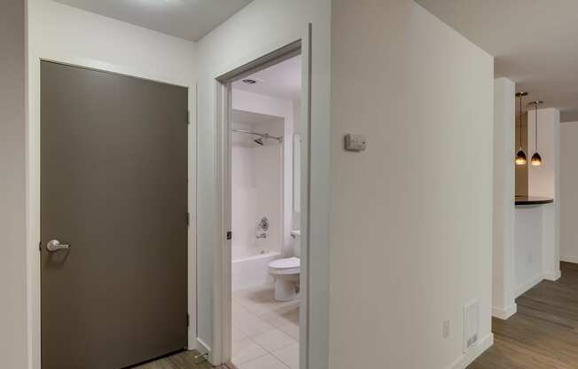 A bathroom with a toilet and sink is visible through an open door.