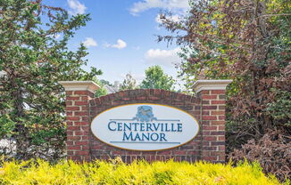 a sign that says centerville manor with trees in the background