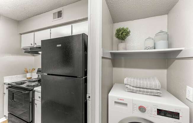 a laundry room with a refrigerator and a washing machine