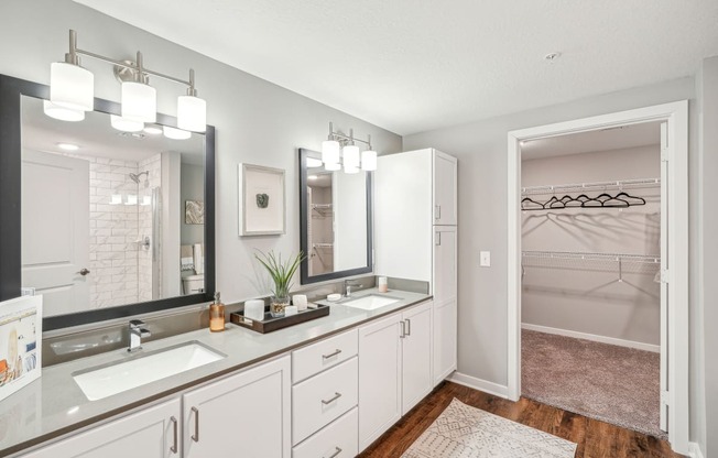 a white bathroom with two sinks and a mirror
