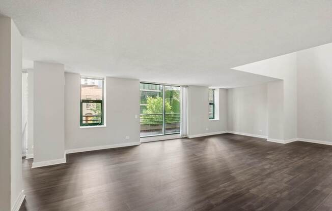 A large empty room with wooden floors and white walls.