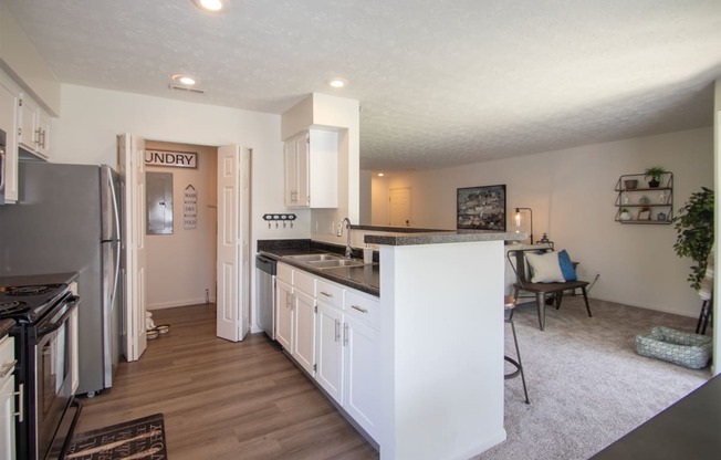 This is a photo of the kitchen and living room of the 1100 square foot 2 bedroom Kettering floor plan at Washington Park Apartments in Centerville, OH.