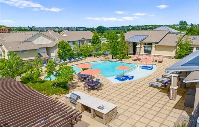 an aerial view of an outdoor pool with tables and umbrellas