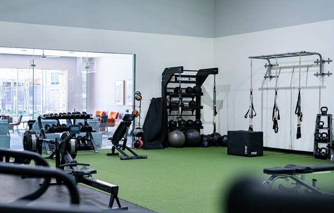 a gym with weights and other exercise equipment on a green carpet