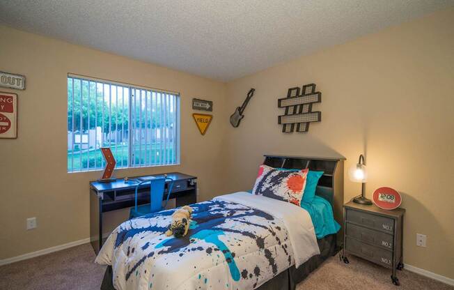 A bedroom with a bed, a desk, and a window at Sterling Point Apartment Homes, Arizona, 85042
