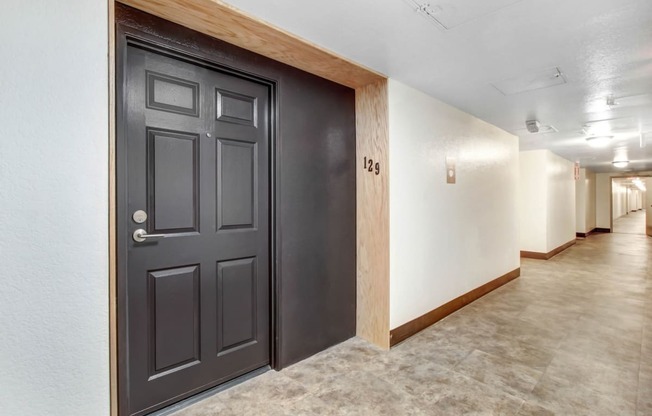 a photo of a hallway with a door at the end of the hallway
