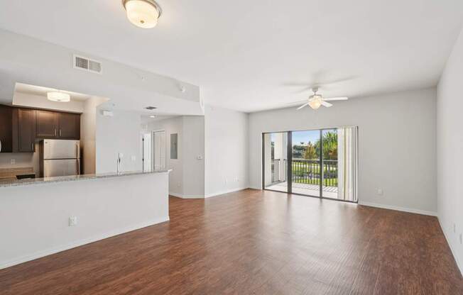 A spacious room with wooden floors and a ceiling fan.
