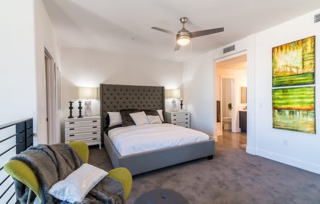 A bedroom with a bed and ceiling fan and bathroom