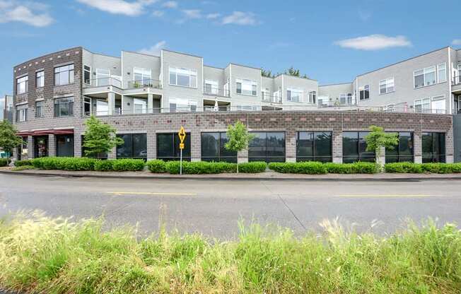 A row of modern buildings with a yellow pedestrian crossing sign in front.