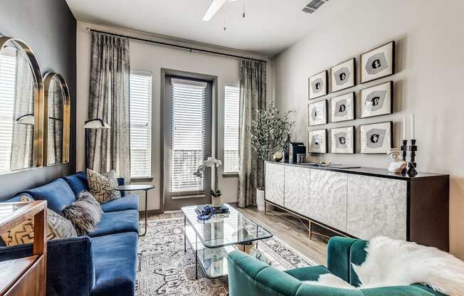 a living room with a blue couch and a glass coffee table