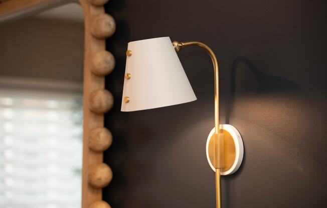 a lamp with a white lamp shade and a mirror