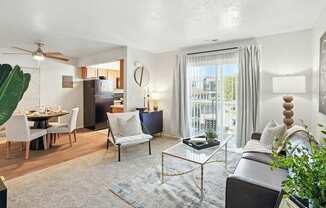 A living room with a grey couch, a coffee table, and a dining table with chairs.