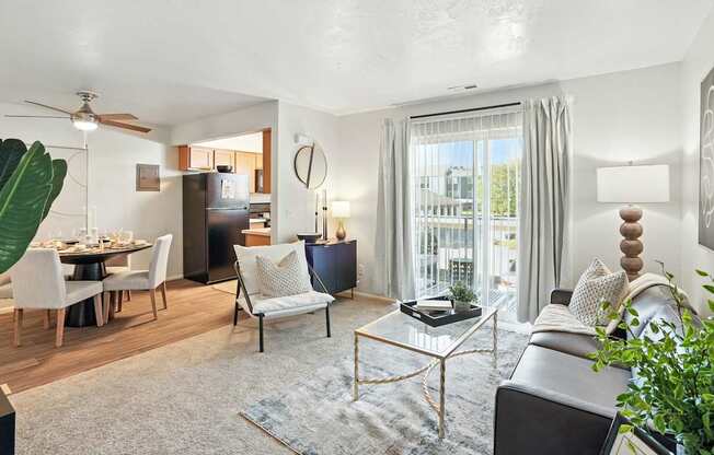 A living room with a grey couch, a coffee table, and a dining table with chairs.