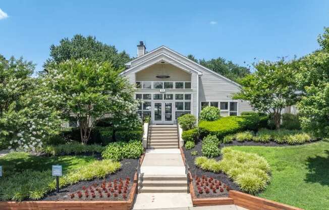 A house with a front yard and a set of stairs leading to the front door.
