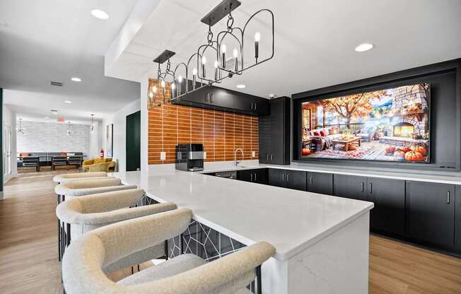 A modern kitchen with a long white island and bar stools.