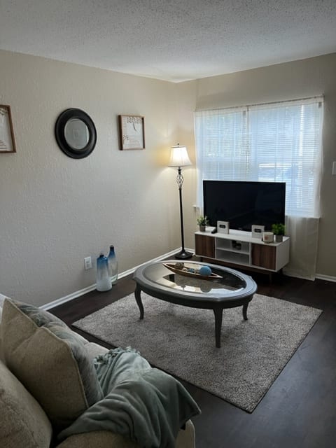 a living room with a tv and a fan