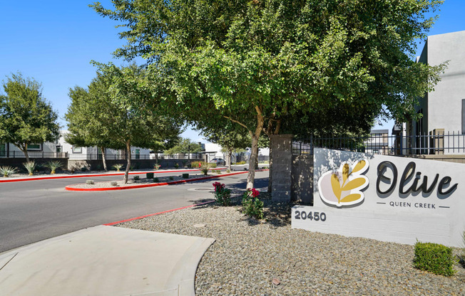 a sign in front of an office building with a tree