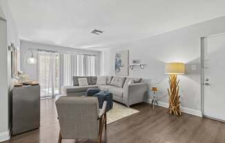 A living room with a grey couch and a chair.
