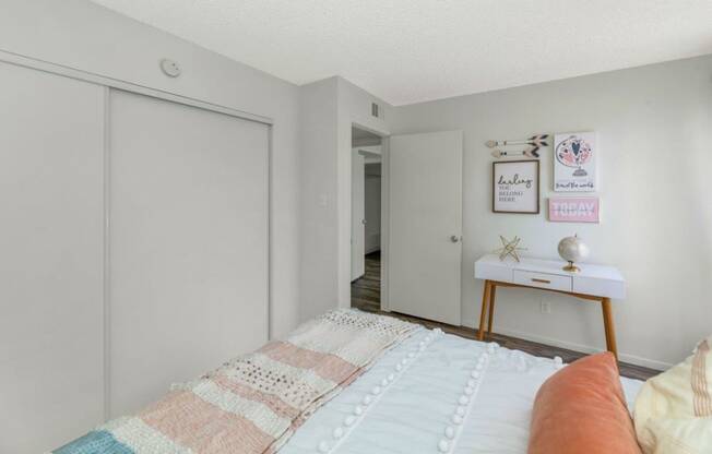 a bedroom with a bed and a desk and a closet