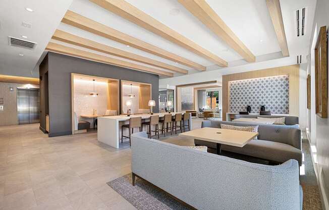 Resident lounge with flexible seating, work tables, and a warm inviting atmosphere