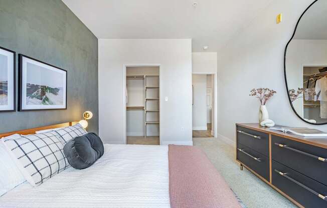 A bedroom with a large bed and a mirror on the wall.