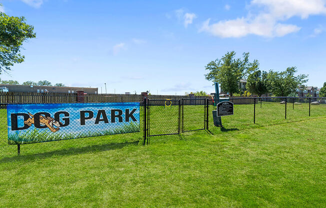 a sign that says dog park on the side of a fence