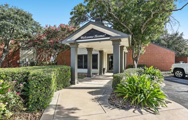 Leasing office entrance with beautiful foliage at Hunters Chase in Austin, TX