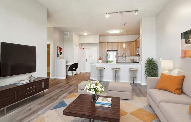 A modern living room with a flat screen TV, a coffee table, and a couch.
