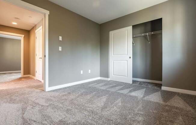 A room with a carpeted floor and a white door.
