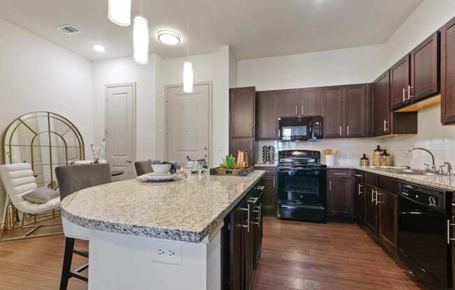 a kitchen with black appliances and a granite counter top