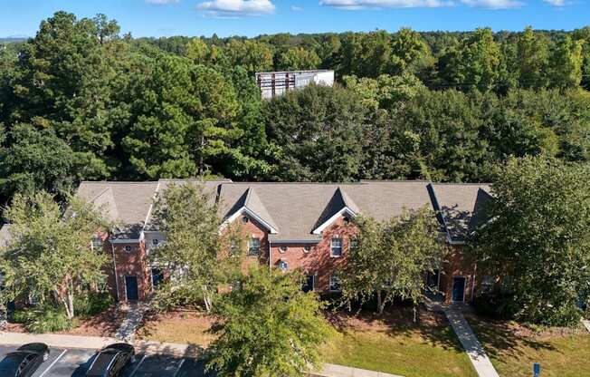 A large building surrounded by trees and a parking lot.
