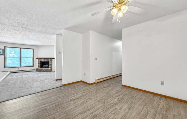 A room with a fireplace and a window overlooking a snowy landscape.