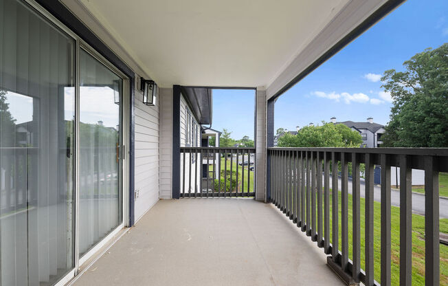 a large balcony with glass doors and a view of the yard