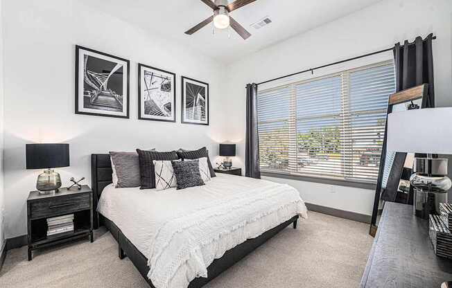 A bedroom with a bed, nightstand, and pictures on the wall.