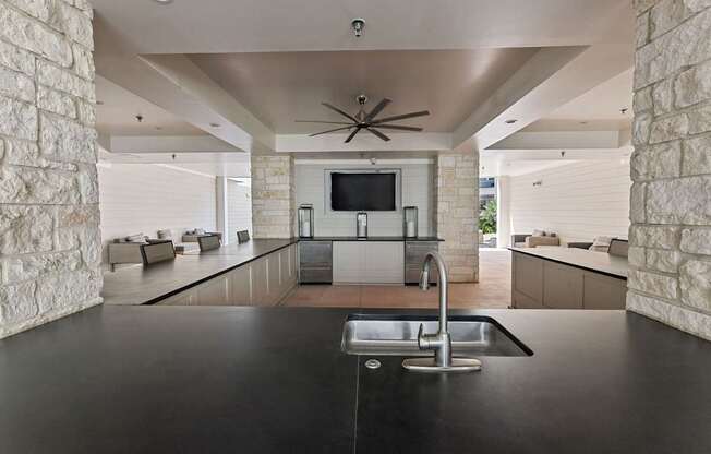 A modern kitchen with a black countertop and a ceiling fan.