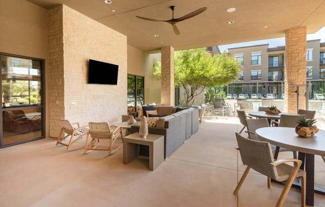 A modern outdoor seating area with a television and pineapple decorations.