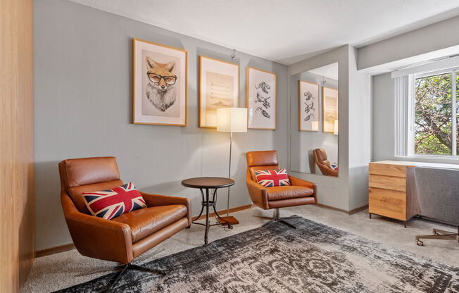 a living room with leather chairs and a rug and a window