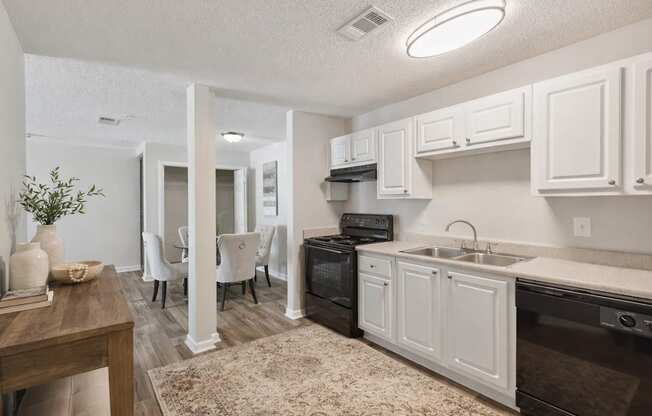 A kitchen with white cabinets and a black oven.