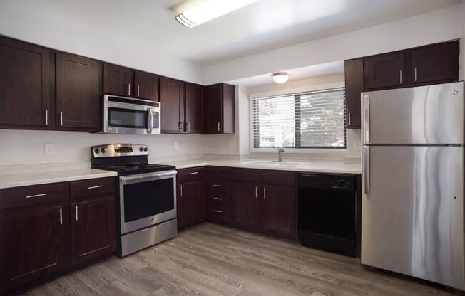 Kitchen with dark wood cabinets and stainless steel appliances  at Governor's Park, Fort Collins, 80525