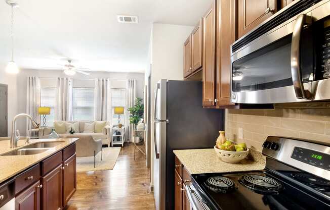 full kitchen with stainless steel appliances and granite counter tops and a view of the living