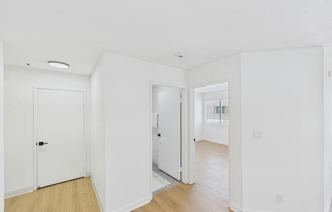 A white room with a door and a window.