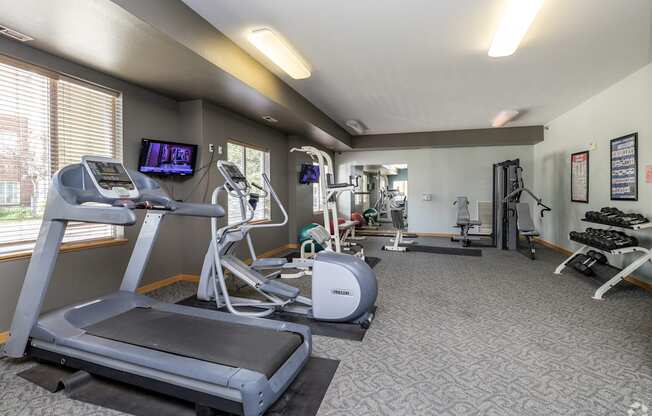 A gym with treadmills, elliptical machines, and other exercise equipment.