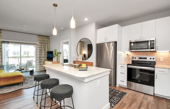 an open kitchen with a large island with three stools