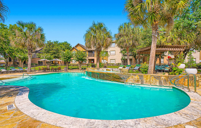 a swimming pool with palm trees and a resort style pool at River Pointe, Texas, 77304