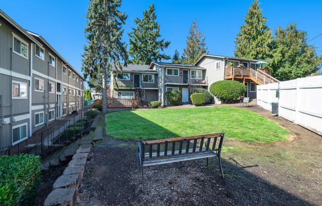 a park bench in a yard in front of houses