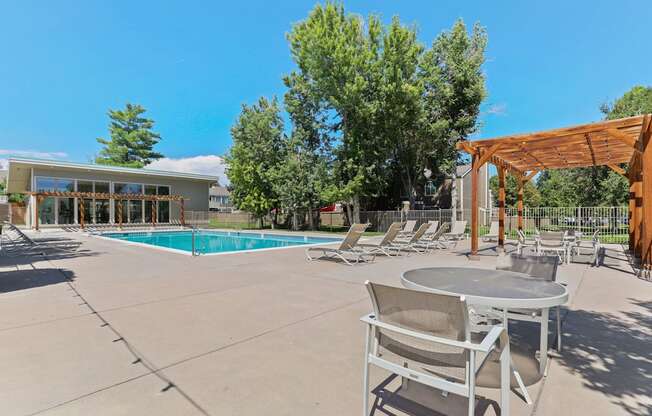 A poolside area with a table and chairs.